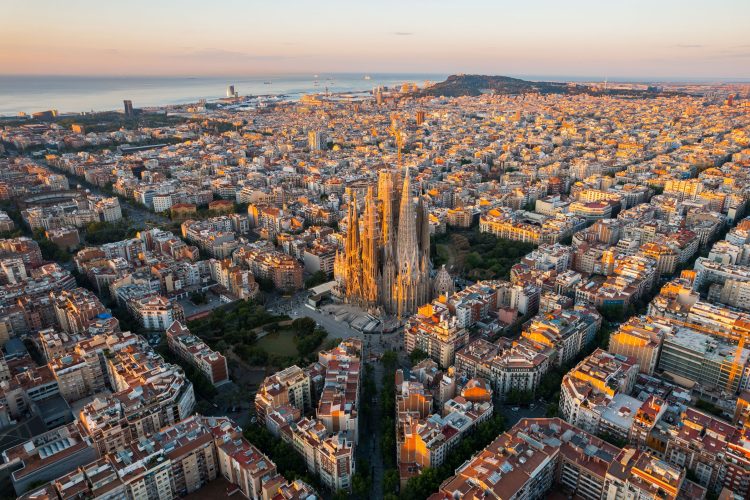 Aerial view of Barcelona Eixample residential district and Sagrada Familia Basilica at sunrise. Catalonia, Spain. Cityscape with typical urban octagon blocks; Shutterstock ID 2163690845; purchase_order: -; job: -; client: -; other: -